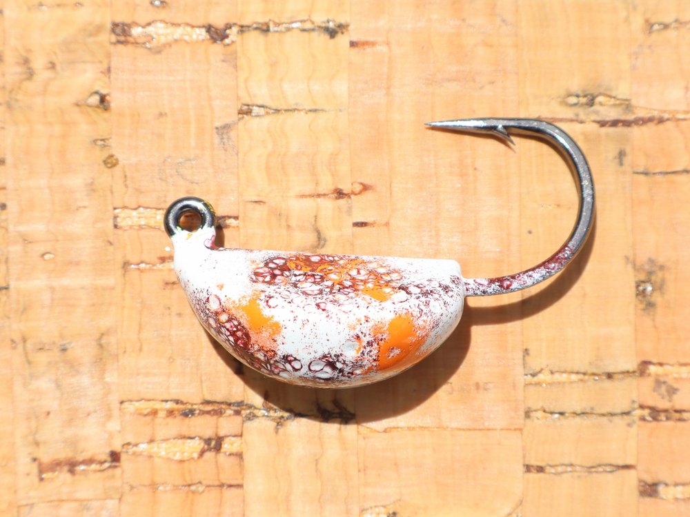A jig head in white with orange and burgundy crackle powder coat